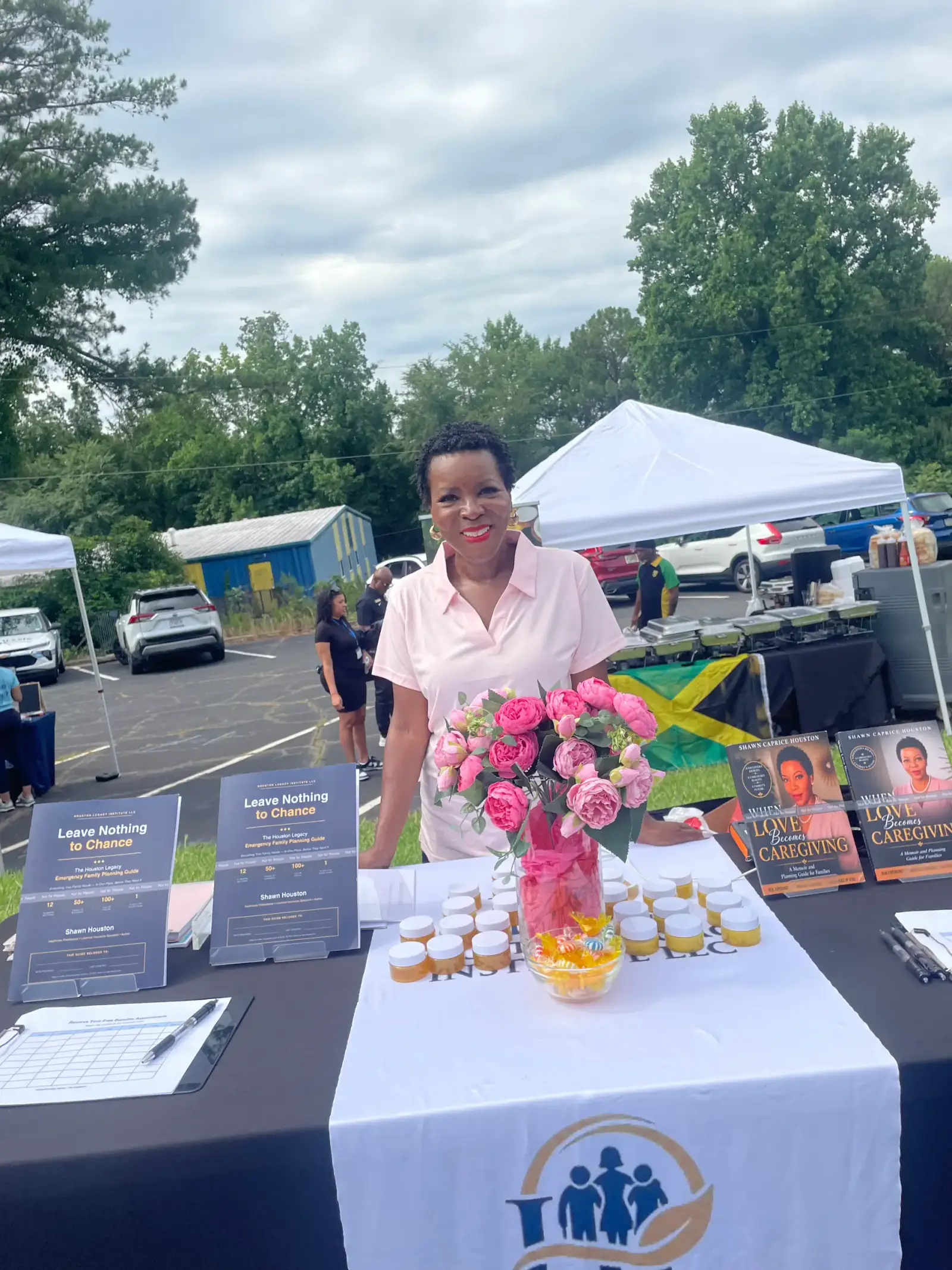 Shawn Caprice Houston standing behind a community table with her books, flowers, and family-planning materials