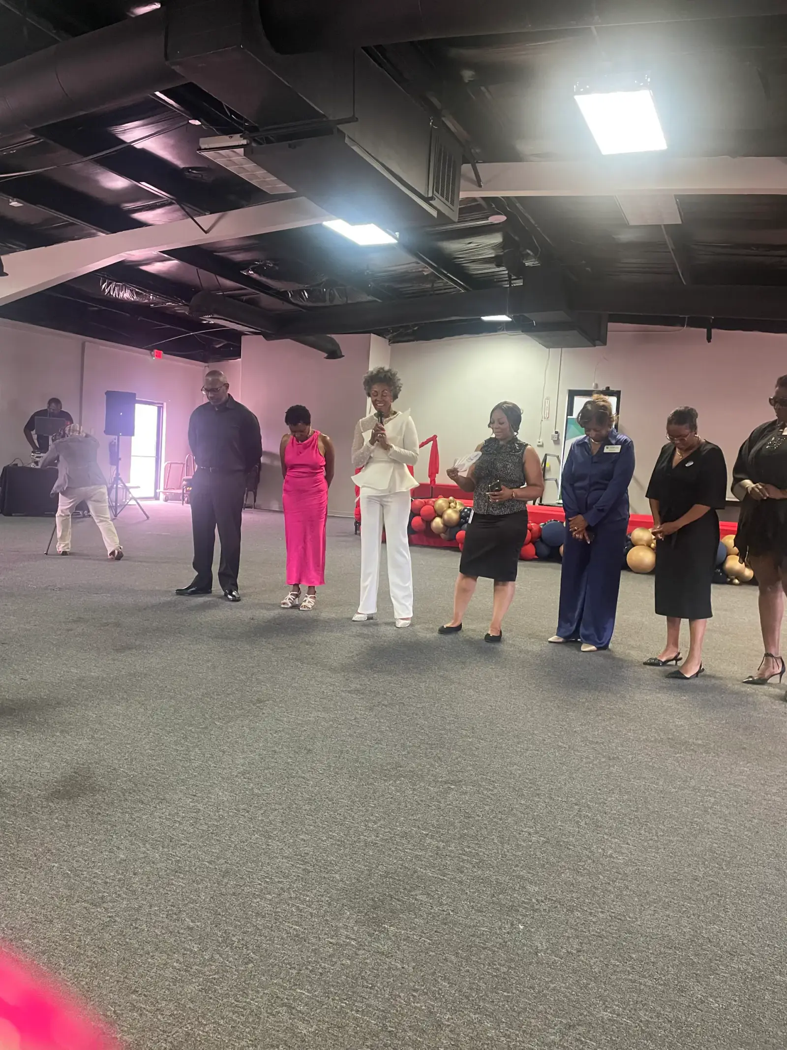 Shawn Caprice Houston holding a microphone while speaking with a group of community attendees